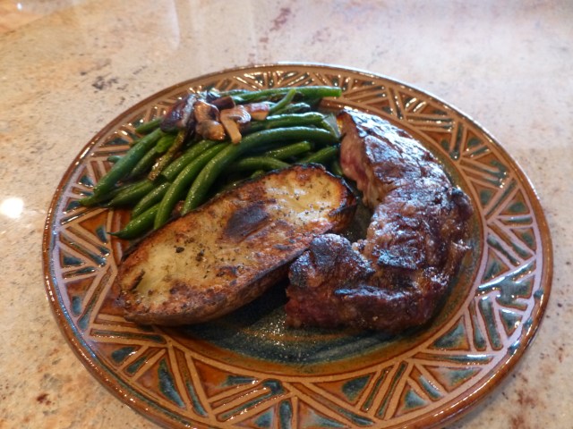 Steak, baked/grilled potato and green beans with mushrooms and sage