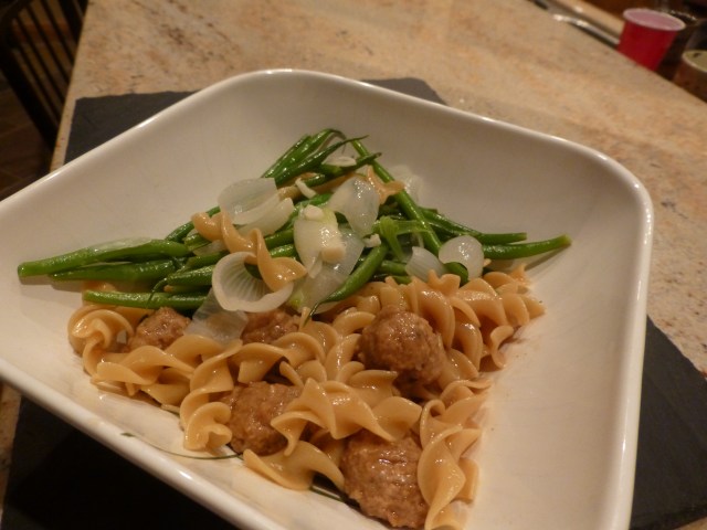 Turkey meatballs with gravy, noodles, and green beans with pearl onions and slivered garlic