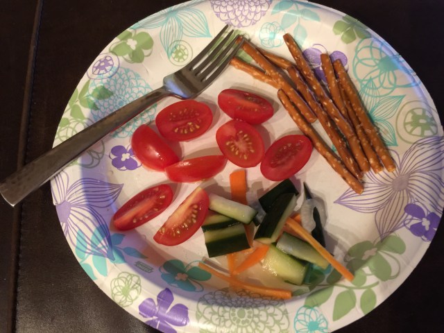 Snack of pickled vegetables, cherry tomatoes, and pretzel sticks